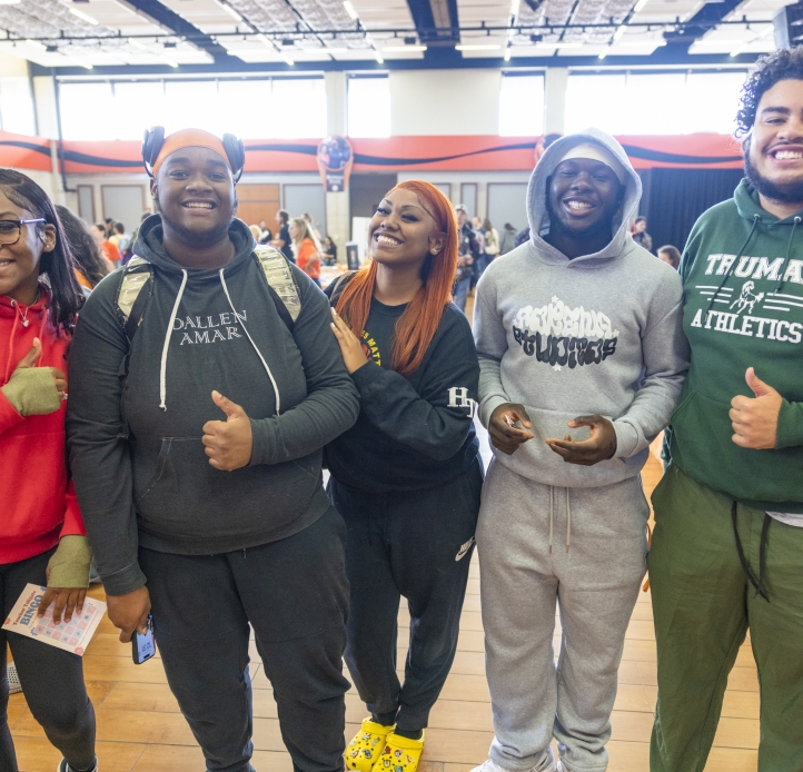five african american students giving the camera a thumbs up